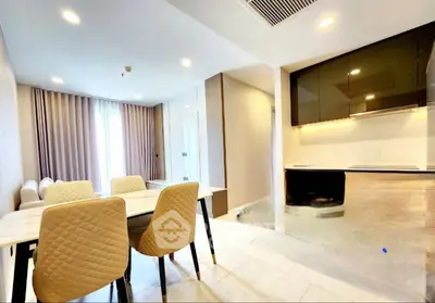 Modern open-layout dining and kitchen area with elegant furnishings and ample natural light.