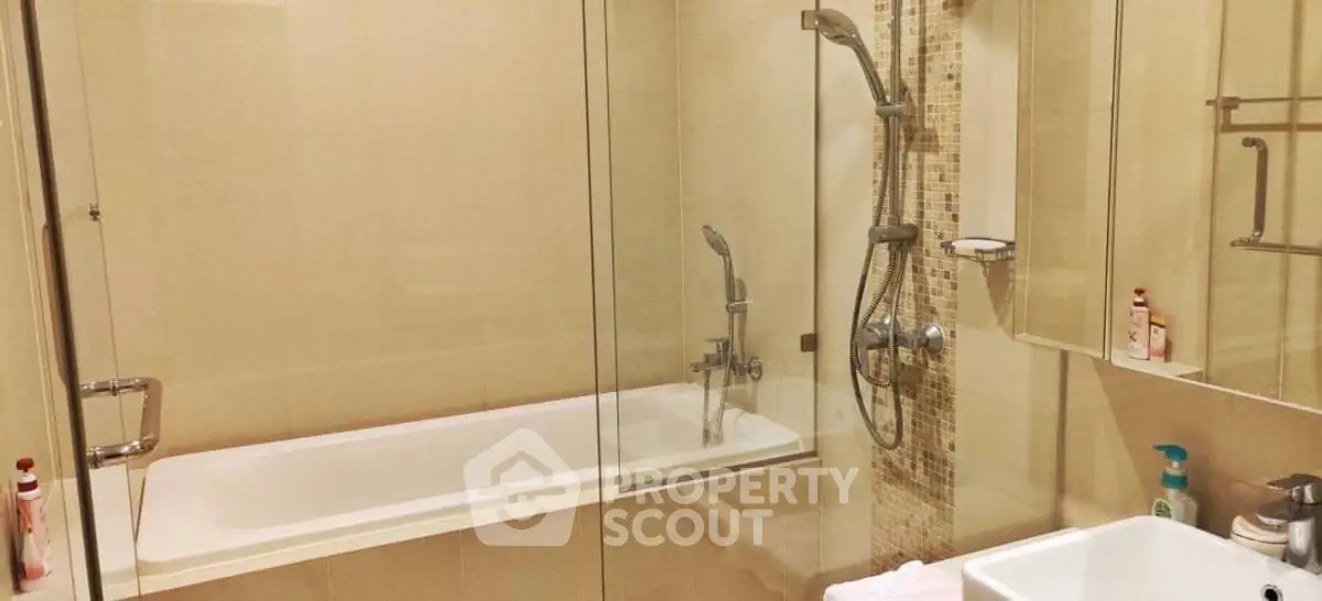 Modern bathroom with glass shower and bathtub in a stylish apartment.