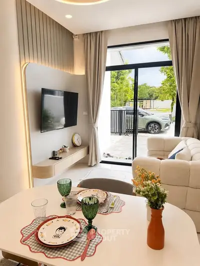 Modern living room with stylish decor and large glass doors opening to a scenic view.