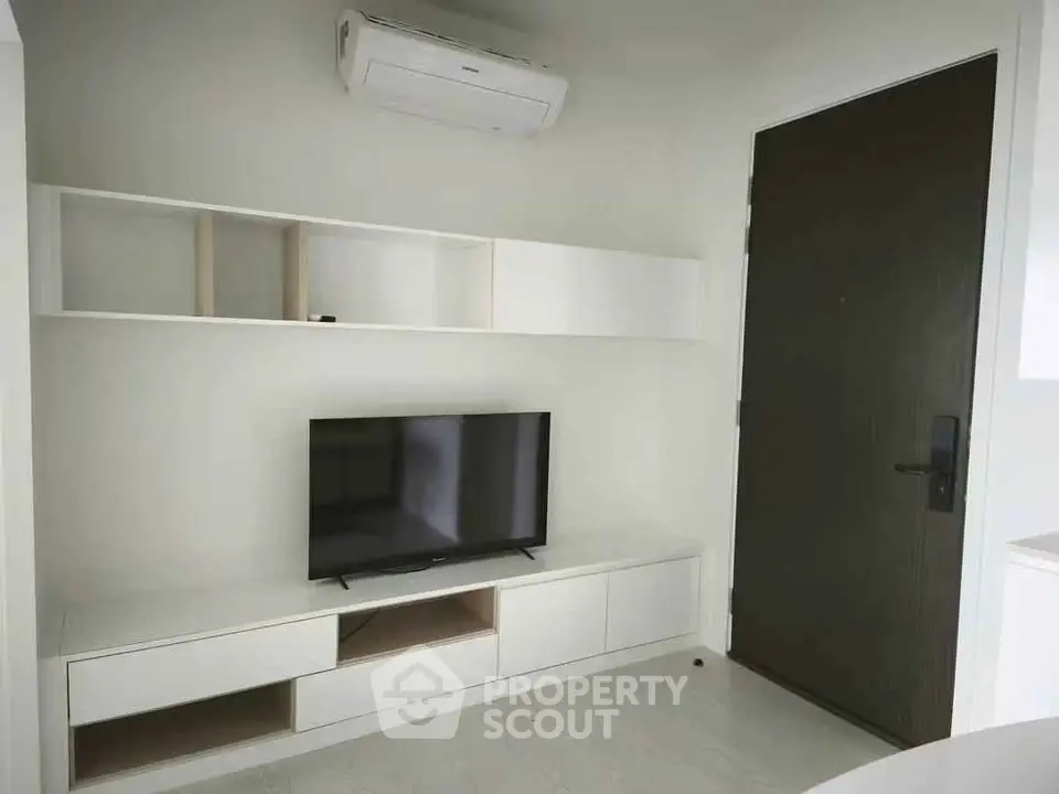 Modern living room with sleek TV unit and air conditioning, perfect for cozy entertainment.