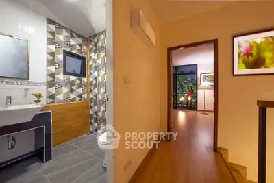 Modern apartment interior with stylish bathroom and cozy hallway leading to a bright living area.