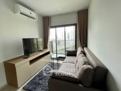 Modern living room with large sofa, TV, and city view from window.