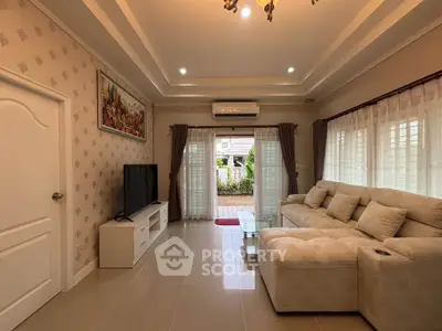 Spacious living room with elegant decor and large windows offering garden view