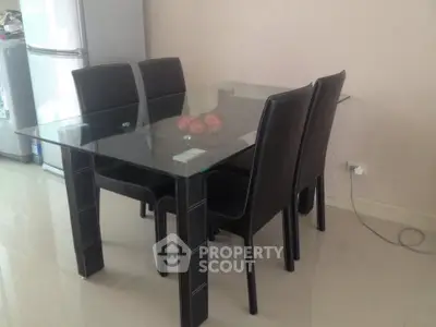 Modern dining area with glass table and black leather chairs in sleek apartment.