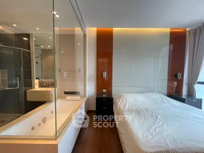 Luxurious bedroom with glass-walled ensuite bathroom and modern design