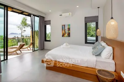 Luxurious bedroom with stunning balcony view and modern decor in tropical setting.