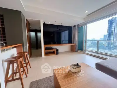 Spacious modern living room with city view and stylish decor in high-rise apartment.