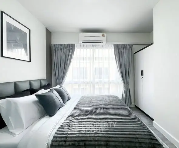 Modern bedroom with stylish decor and natural light in a contemporary apartment.
