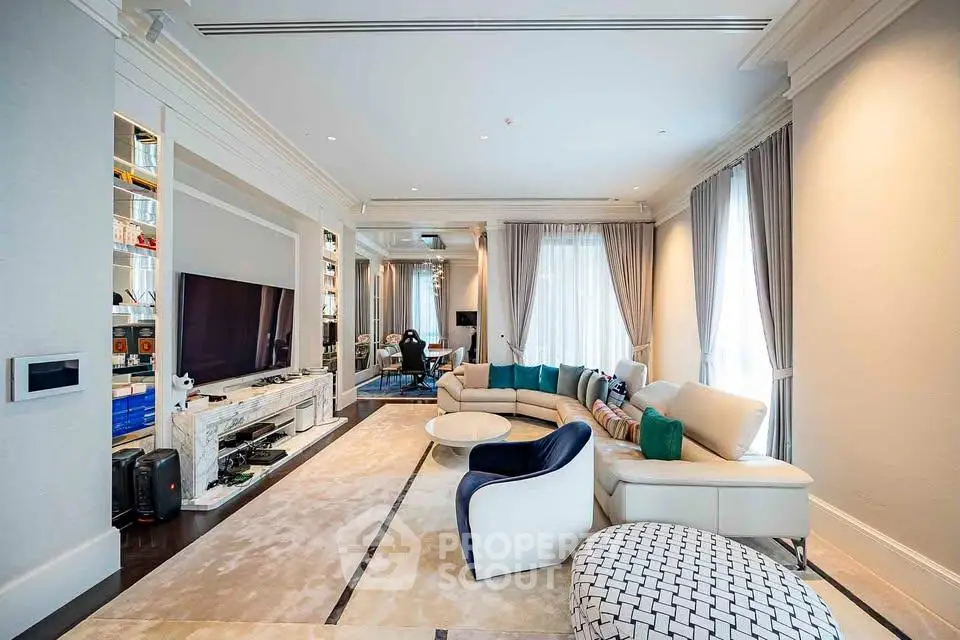 Luxurious living room with elegant decor, large TV, and plush seating in a spacious open layout.