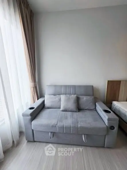 Modern living room with stylish gray sofa and elegant curtains