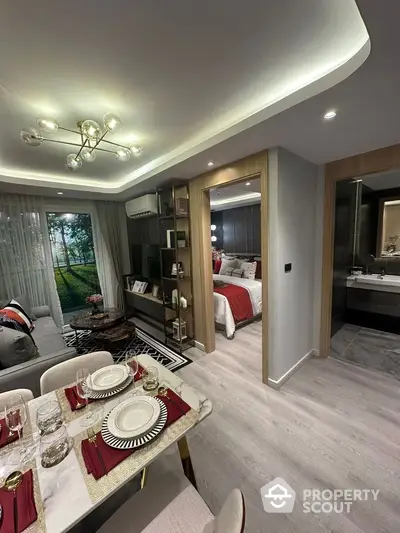 Modern open-plan living and dining area with elegant decor, leading to a cozy bedroom and stylish bathroom.