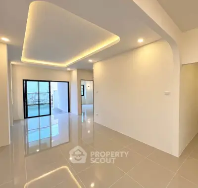 Spacious modern living room with sleek tile flooring and ambient ceiling lighting