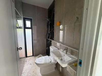 Modern bathroom with sleek fixtures and large window for natural light.