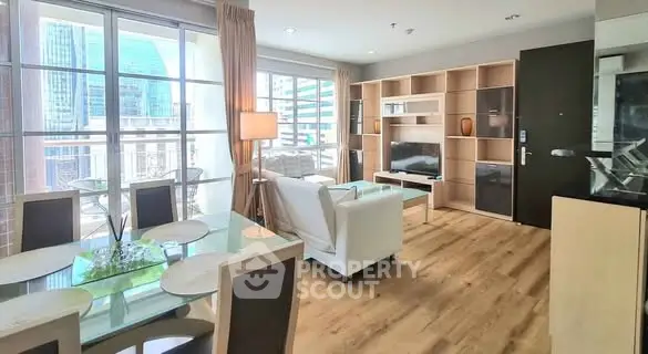 Modern living room with dining area and city view, featuring elegant furniture and natural light.