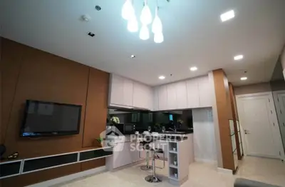 Modern open-layout kitchen with sleek cabinetry and stylish lighting in a contemporary apartment.