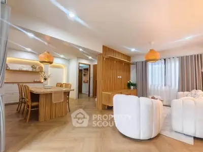 Spacious open-plan living and dining area with modern decor and natural lighting.