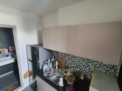 Compact kitchen with modern cabinetry and mosaic backsplash, featuring a stainless steel fridge and sink.