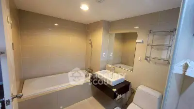 Modern bathroom with bathtub, sink, and toilet in a sleek design.