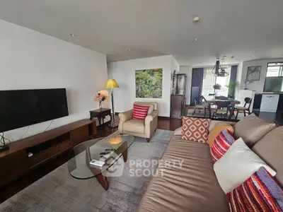 Spacious living room with modern decor and open dining area, perfect for entertaining guests.