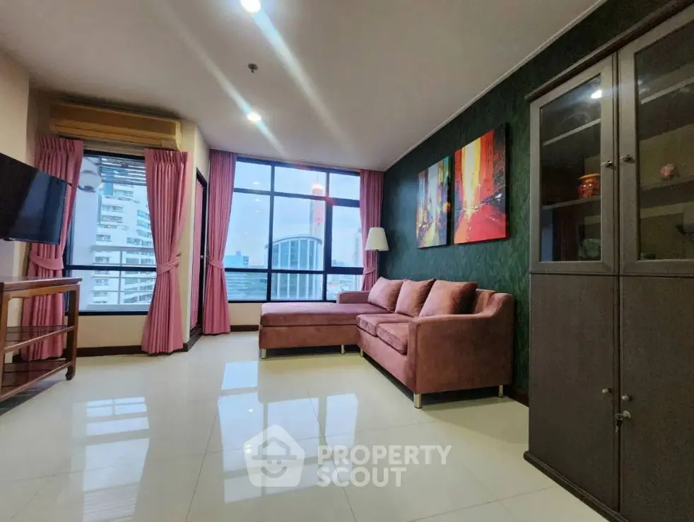 Spacious living room with modern decor and city view, featuring a comfortable sofa and stylish artwork.