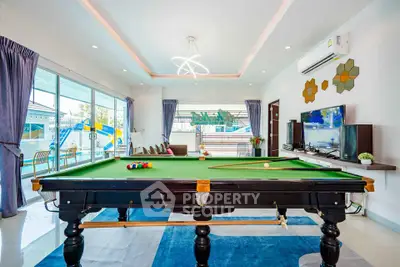 Luxurious living room with pool table and modern decor, perfect for entertainment and relaxation.