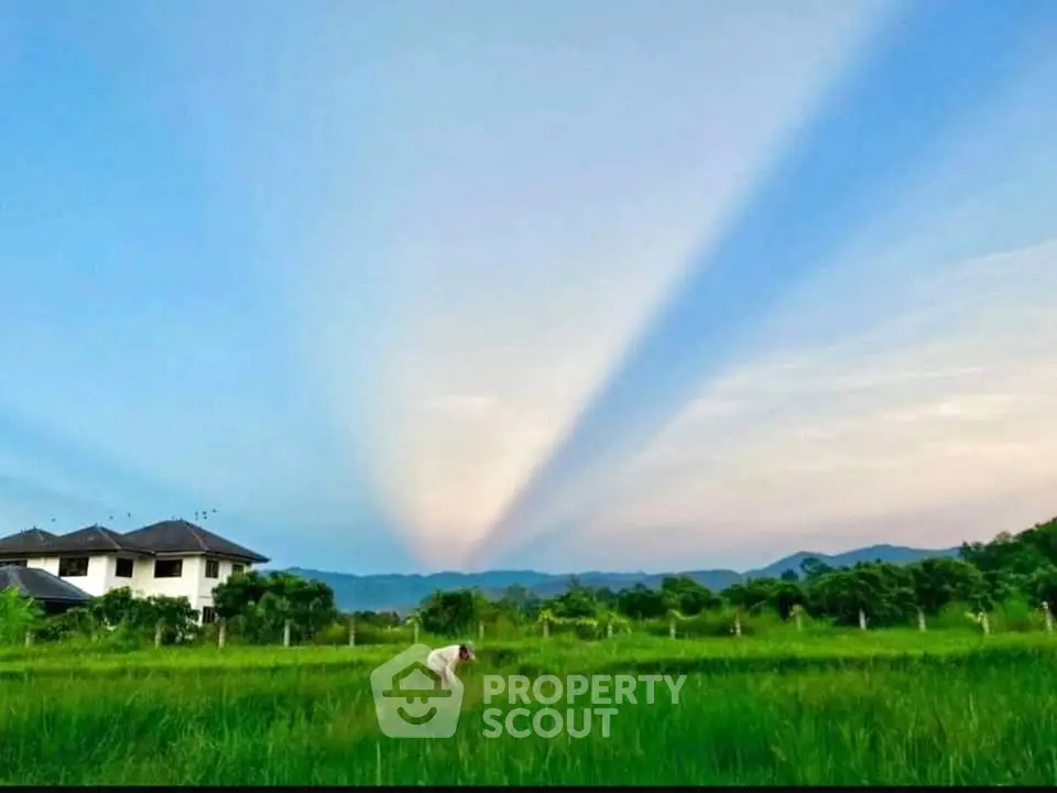 Stunning countryside property with expansive green fields and mountain views.