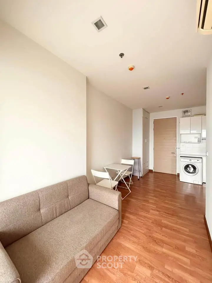 Modern living room with compact dining area and in-unit laundry