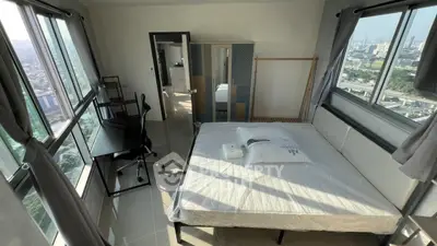 Spacious bedroom with panoramic city views and modern furnishings.
