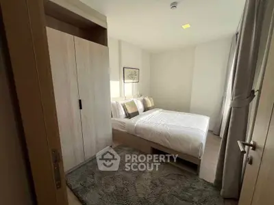 Cozy bedroom with modern decor and ample natural light, featuring a plush carpet and stylish wardrobe.