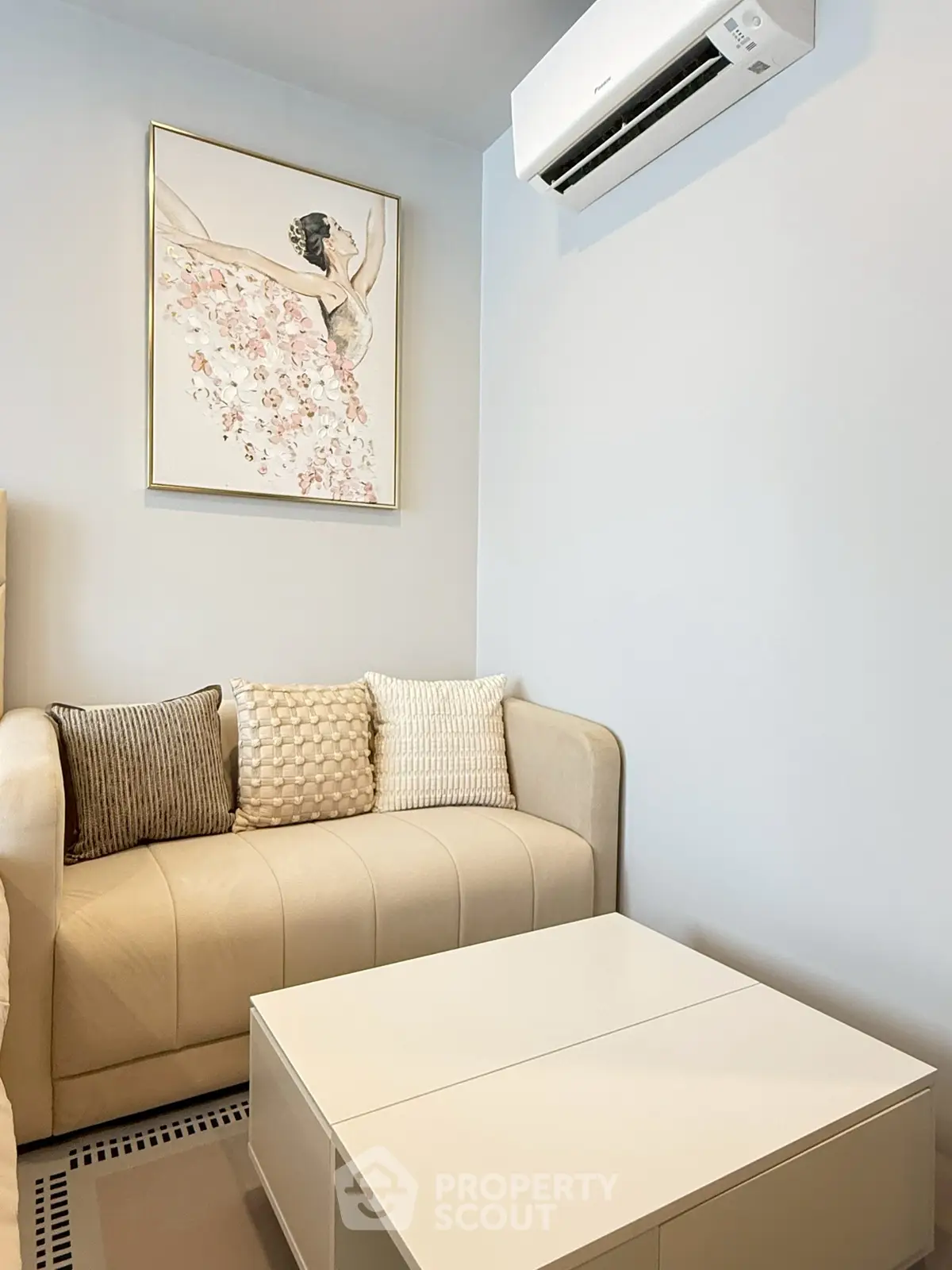 Chic living room with elegant sofa, modern art, and air conditioning unit.