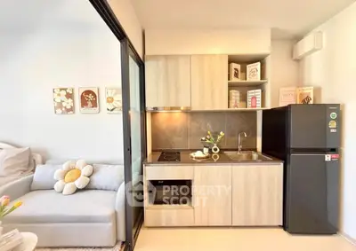 Modern compact kitchen with sleek appliances and cozy living area, perfect for urban living.