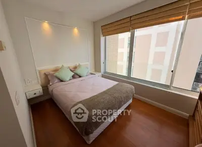 Cozy bedroom with large window and modern decor in urban apartment