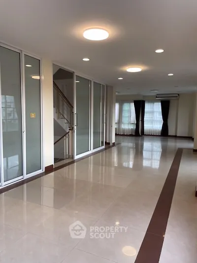 Spacious modern living room with large windows and elegant lighting