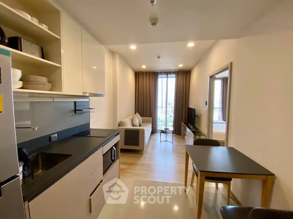 Modern open-layout kitchen and living room with sleek design and natural light.