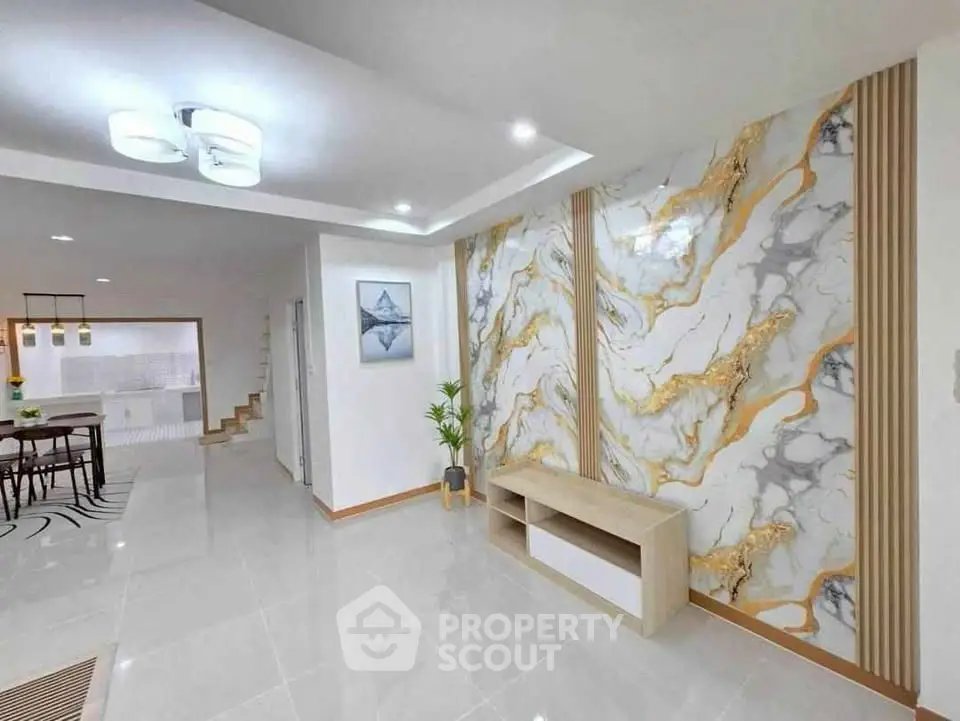Luxurious modern living room with elegant marble accent wall and sleek lighting.