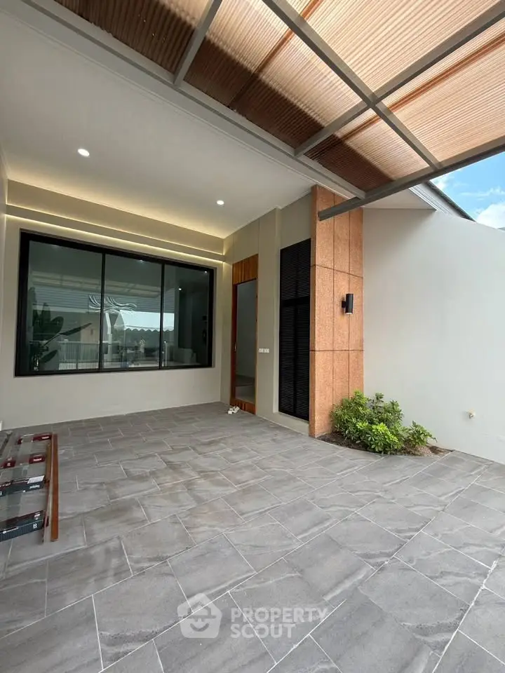 Modern home entrance with stylish covered patio and large window