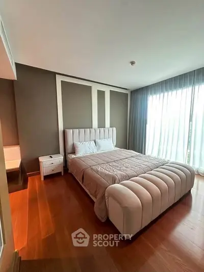 Luxurious bedroom with elegant decor and large window offering natural light