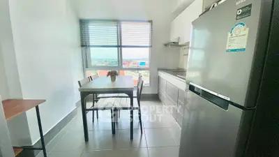 Modern kitchen with dining area and scenic view, featuring sleek appliances and ample natural light.