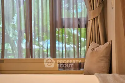 Cozy bedroom with elegant curtains and lush greenery view, perfect for relaxation.