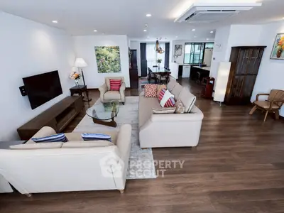 Spacious modern living room with elegant decor and open layout, featuring hardwood floors and stylish furniture.