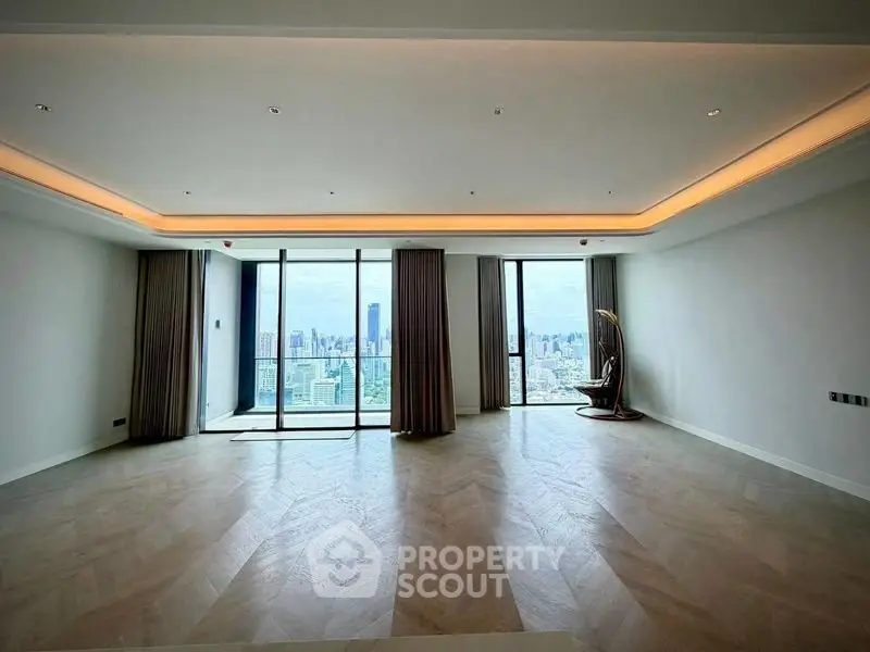 Spacious modern living room with panoramic city view and elegant lighting.