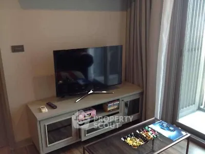 Cozy living room with modern TV setup and balcony view
