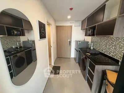 Modern kitchen with sleek appliances and stylish backsplash in compact layout.