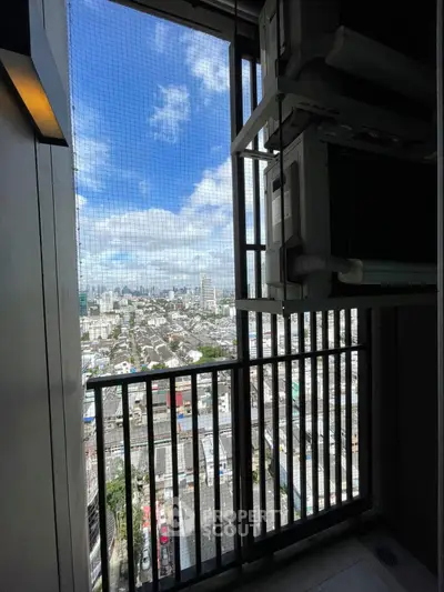 Stunning high-rise balcony view with cityscape and clear blue sky.
