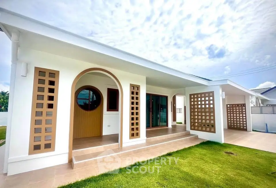 Modern single-story house with unique architectural design and spacious front yard.
