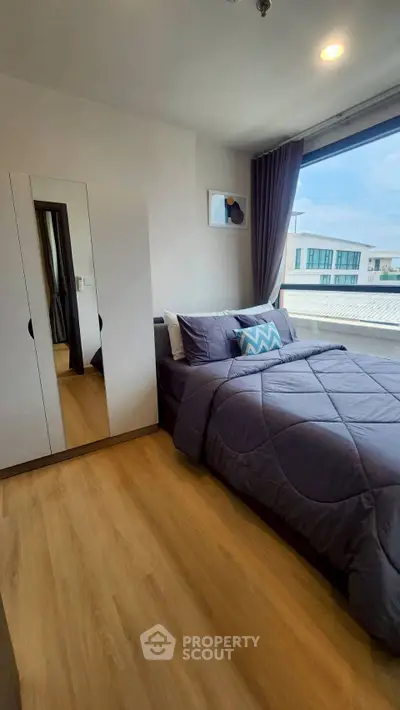 Modern bedroom with large window and stylish decor in urban apartment