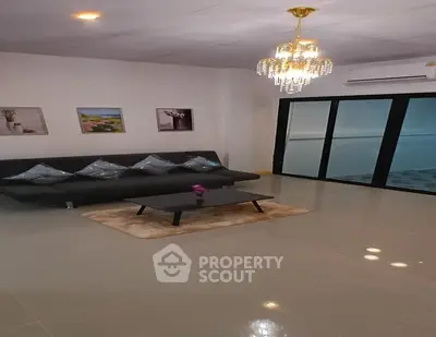 Elegant living room with modern chandelier and sleek black sofa