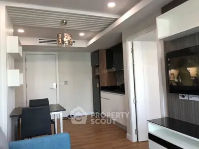 Modern apartment interior with open kitchen and stylish living area, featuring sleek furniture and contemporary lighting.