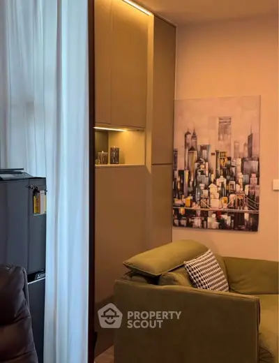 Modern living room with stylish decor and cityscape artwork, featuring a cozy green sofa and sleek storage solutions.