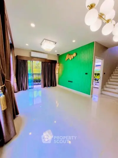 Spacious living room with vibrant green accent wall and modern lighting